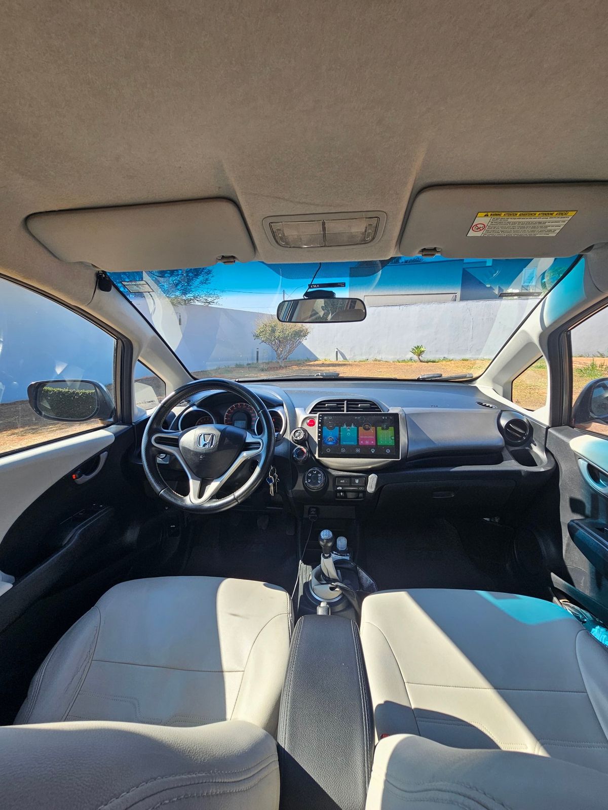 Interior do Honda New Fit com volante em couro e multimídia